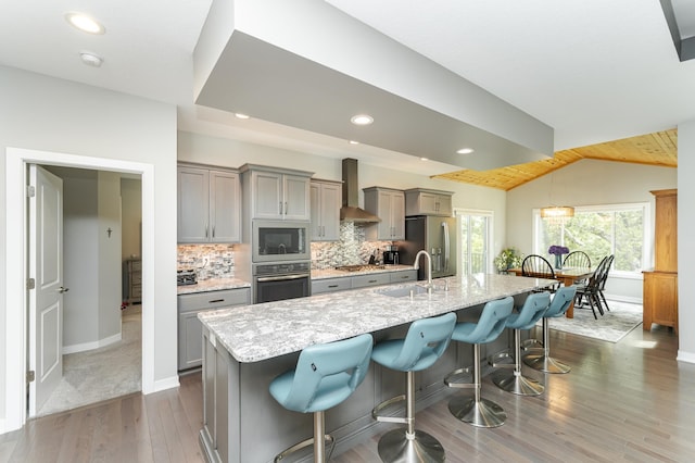 4338 Stone Crest Ln NE, Rochester, MN 55906 - kitchen with appliances with stainless steel finishes, gray cabinets, a sink, wall chimney range hood, and lofted ceiling