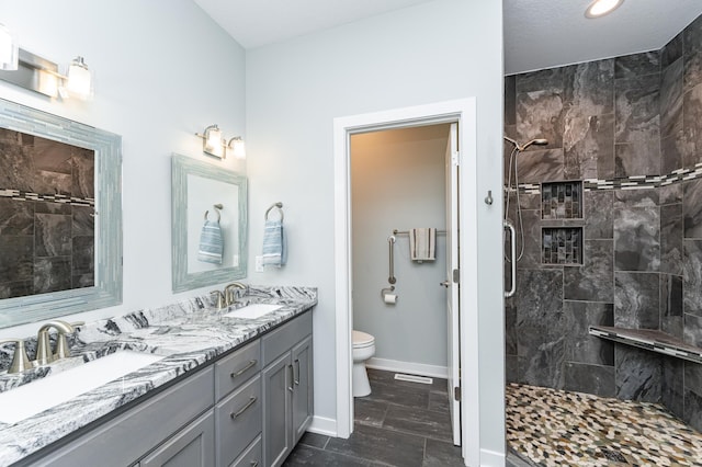 4338 Stone Crest Ln NE, Rochester, MN 55906 - full bathroom featuring toilet, double vanity, tiled shower, baseboards, and recessed lighting