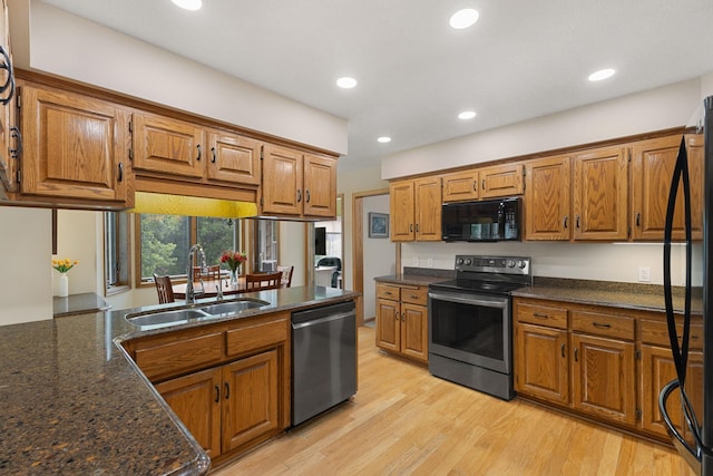14023 Yellow Pine St NW, Andover, MN 55304 - kitchen featuring black appliances, brown cabinetry, light wood-style floors, recessed lighting, and dark stone counters