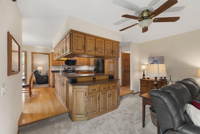 14023 Yellow Pine St NW, Andover, MN 55304 - kitchen featuring open floor plan, dark countertops, black appliances, a ceiling fan, and brown cabinetry
