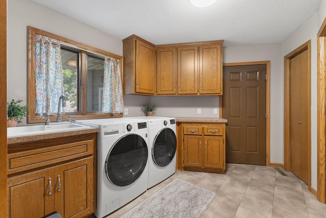 14023 Yellow Pine St NW, Andover, MN 55304 - laundry area featuring cabinet space, washing machine and dryer, a textured ceiling, and light tile patterned flooring
