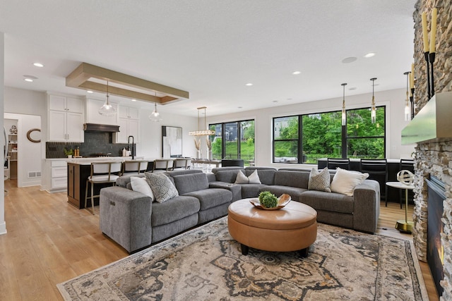 4998 Beach St NE, Prior Lake, MN 55372 - living area with light wood finished floors, plenty of natural light, recessed lighting, a stone fireplace, and a tray ceiling