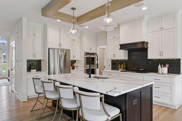 4998 Beach St NE, Prior Lake, MN 55372 - kitchen with appliances with stainless steel finishes, a kitchen island with sink, white cabinets, recessed lighting, and light wood finished floors