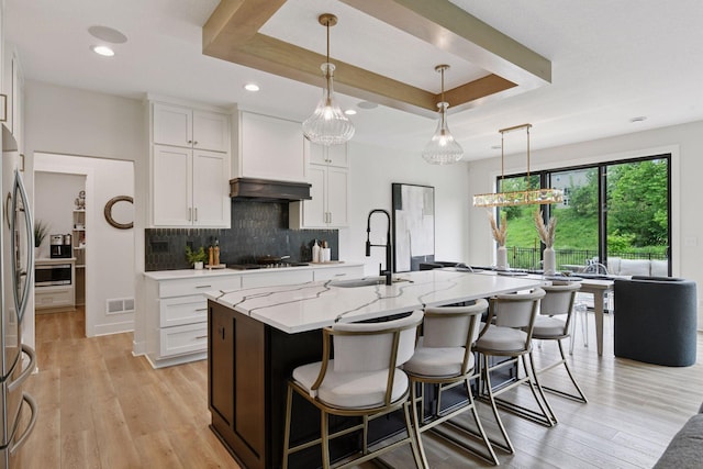 4998 Beach St NE, Prior Lake, MN 55372 - kitchen featuring white cabinets, decorative backsplash, light stone counters, light wood-style floors, and recessed lighting