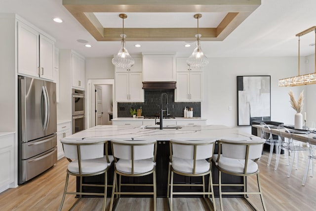 4998 Beach St NE, Prior Lake, MN 55372 - kitchen with appliances with stainless steel finishes, a raised ceiling, decorative backsplash, light wood-style flooring, and recessed lighting