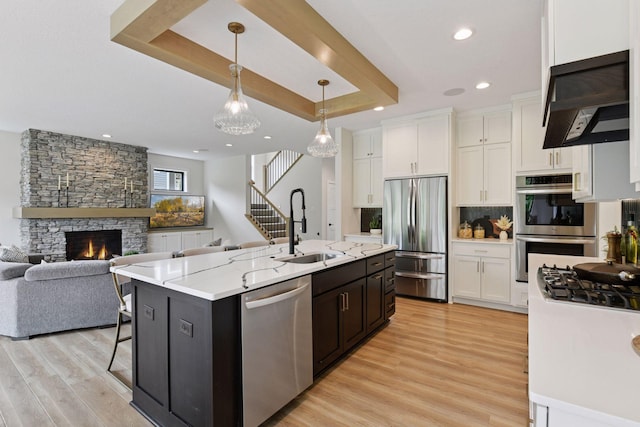 4998 Beach St NE, Prior Lake, MN 55372 - kitchen with appliances with stainless steel finishes, a sink, white cabinets, light wood finished floors, and recessed lighting