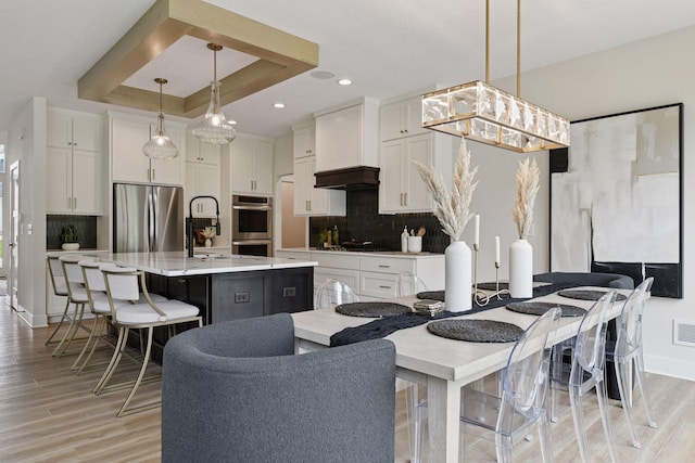 4998 Beach St NE, Prior Lake, MN 55372 - kitchen featuring appliances with stainless steel finishes, a raised ceiling, white cabinets, light wood-style floors, and recessed lighting