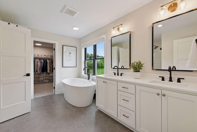 4998 Beach St NE, Prior Lake, MN 55372 - bathroom featuring double vanity, a freestanding tub, a spacious closet, tile patterned floors, and recessed lighting