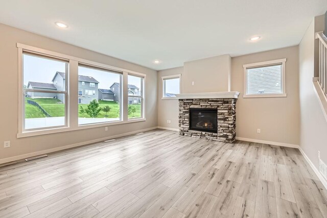 139 144th Ave NW, Andover, MN 55304 - unfurnished living room with light wood-style floors, a stone fireplace, and recessed lighting