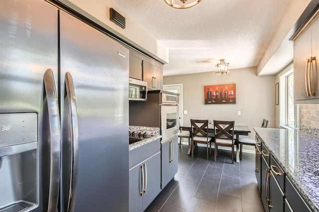 13812 Steven Rd, Burnsville, MN 55337 - kitchen with stainless steel appliances, stone countertops, gray cabinetry, and a textured ceiling