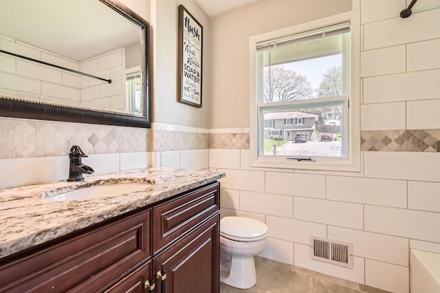 13812 Steven Rd, Burnsville, MN 55337 - bathroom featuring toilet, vanity, a shower, tile walls, and tile patterned floors