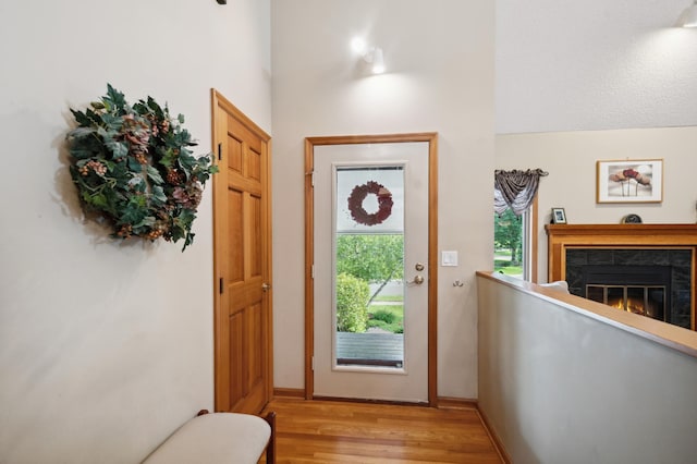 15795 Quebec Cir, Eden Prairie, MN 55346 - foyer featuring light wood-style flooring, a tiled fireplace, and a high ceiling