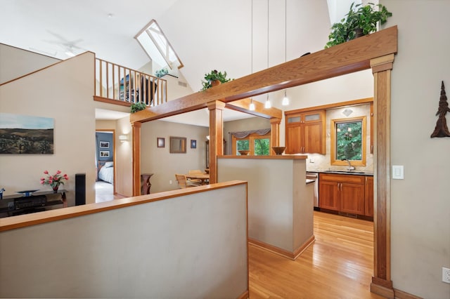 15795 Quebec Cir, Eden Prairie, MN 55346 - kitchen featuring brown cabinetry, light wood-style floors, ornate columns, dishwasher, and pendant lighting