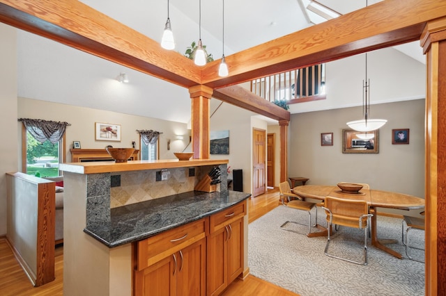 15795 Quebec Cir, Eden Prairie, MN 55346 - kitchen with light wood finished floors, open floor plan, decorative light fixtures, dark stone countertops, and brown cabinetry