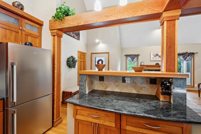 15795 Quebec Cir, Eden Prairie, MN 55346 - kitchen with freestanding refrigerator, light wood-style floors, glass insert cabinets, brown cabinetry, and decorative columns