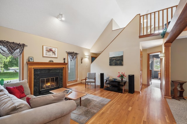 15795 Quebec Cir, Eden Prairie, MN 55346 - living room featuring healthy amount of natural light, high vaulted ceiling, a high end fireplace, light wood-style floors, and ornate columns