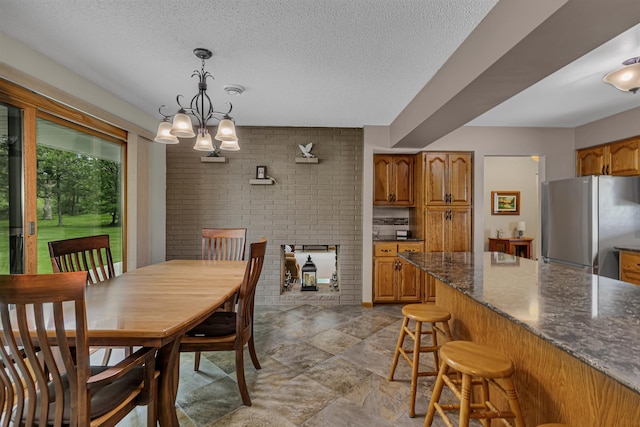 1341 75th Ave NE, Sauk Rapids, MN 56379 - dining room featuring a textured ceiling, brick wall, and a chandelier