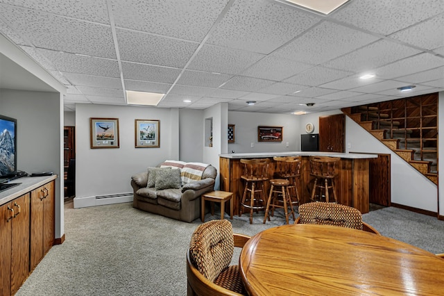 1341 75th Ave NE, Sauk Rapids, MN 56379 - carpeted living area featuring bar area, a baseboard radiator, a paneled ceiling, and stairway