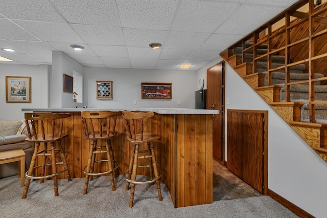 1341 75th Ave NE, Sauk Rapids, MN 56379 - indoor wet bar featuring dark carpet, freestanding refrigerator, a paneled ceiling, and stairs