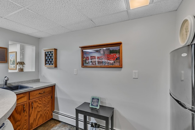 1341 75th Ave NE, Sauk Rapids, MN 56379 - kitchen featuring freestanding refrigerator, a drop ceiling, brown cabinets, and light countertops