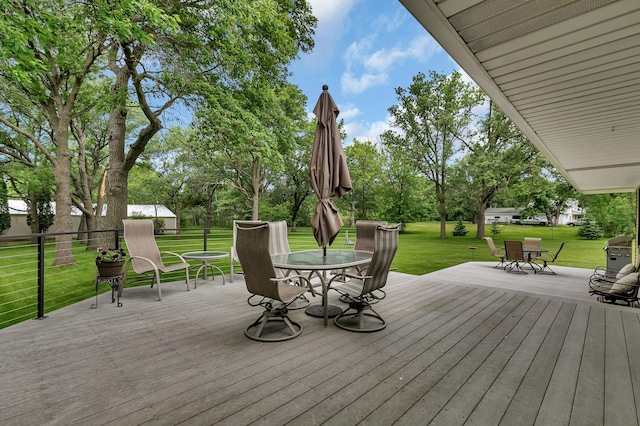 1341 75th Ave NE, Sauk Rapids, MN 56379 - deck with outdoor dining space, a lawn, and view of wooded area