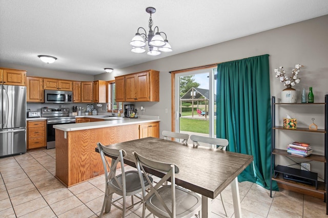 32147 111 1/2 St, Baldwin Twp, MN 55371 - kitchen with appliances with stainless steel finishes, light tile patterned flooring, a chandelier, a peninsula, and light countertops