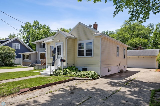 1307 5th St S, Fargo, ND 58103 - view of front facade featuring a chimney, an outdoor structure, a garage, and a front yard