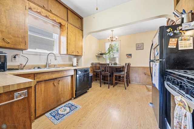 1307 5th St S, Fargo, ND 58103 - kitchen featuring black dishwasher, stainless steel range with gas stovetop, light wood finished floors, a chandelier, and brown cabinets