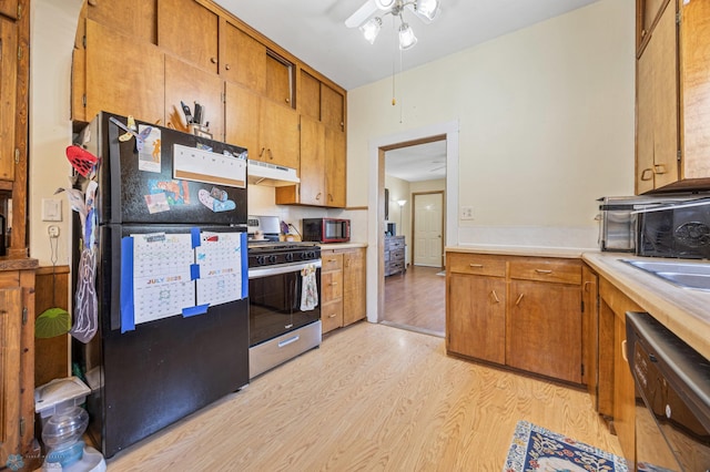 1307 5th St S, Fargo, ND 58103 - kitchen with freestanding refrigerator, stainless steel gas range, dishwasher, under cabinet range hood, and light wood-style flooring