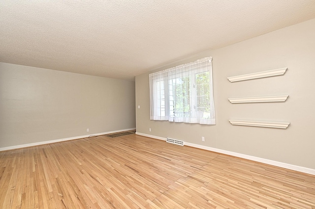 619 9th Ave, Grand Rapids, MN 55744 - spare room with light wood-type flooring, baseboards, and a textured ceiling
