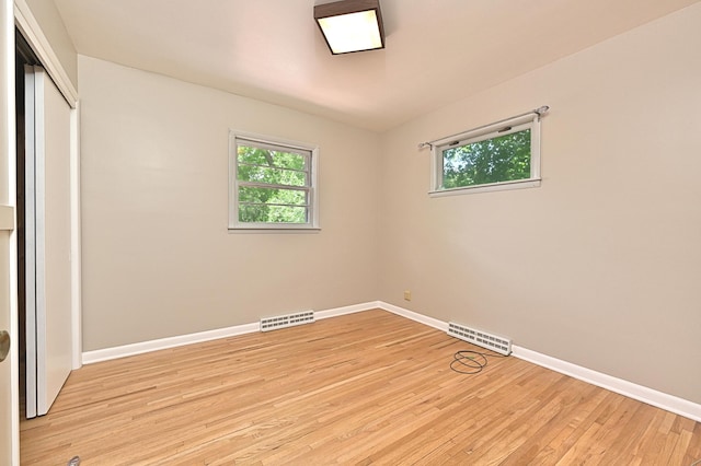 619 9th Ave, Grand Rapids, MN 55744 - unfurnished bedroom featuring baseboards, multiple windows, and light wood-style flooring
