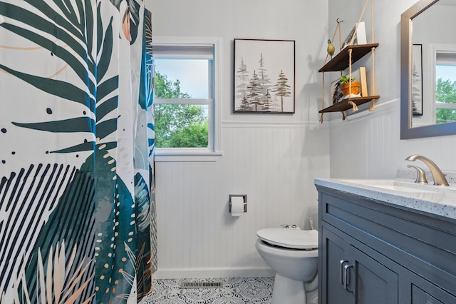 712 Shady Ln SW, Alexandria, MN 56308 - full bath featuring vanity, plenty of natural light, wainscoting, tile patterned flooring, and a shower with curtain