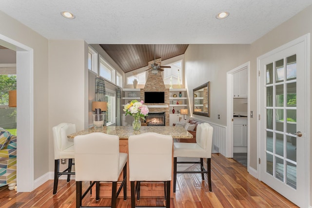 4078 153rd St W, Rosemount, MN 55068 - dining space with wood finished floors, a large fireplace, ceiling fan, lofted ceiling, and built in features