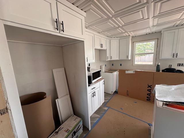 709 Summit St, Aurora, MN 55705 - kitchen featuring white microwave, washer / clothes dryer, and white cabinets