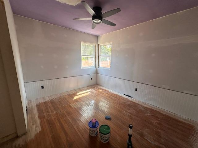 709 Summit St, Aurora, MN 55705 - unfurnished room featuring a wainscoted wall, hardwood / wood-style flooring, and ceiling fan