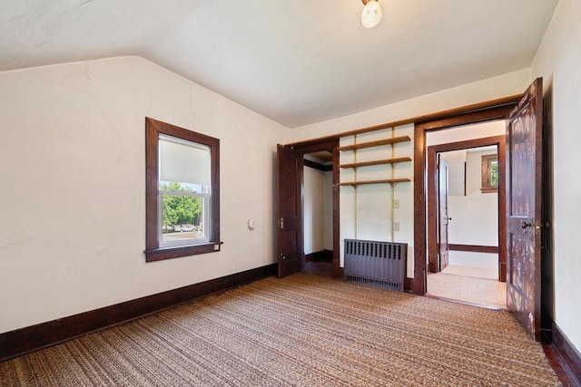 115 Spruce St W, Grey Eagle, MN 56336 - unfurnished bedroom featuring radiator heating unit, carpet, and vaulted ceiling