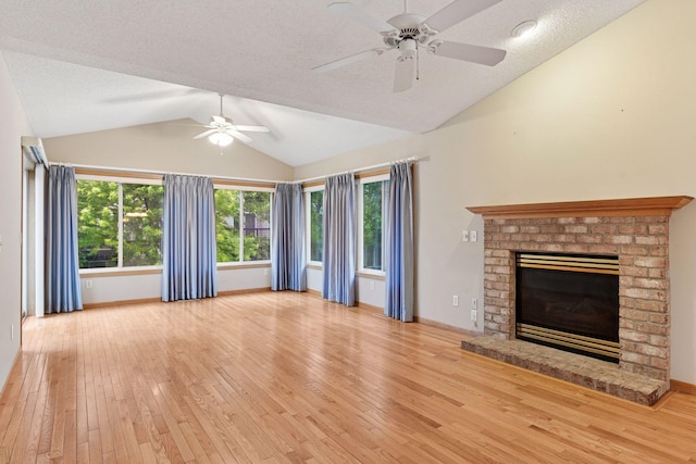 1040 Primrose Ln, Waconia, MN 55387 - unfurnished living room featuring a ceiling fan, lofted ceiling, wood-type flooring, a brick fireplace, and a textured ceiling