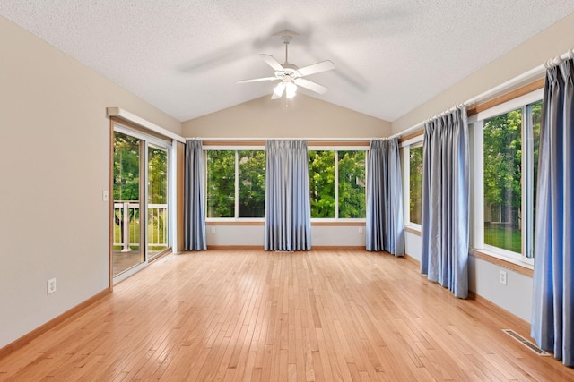 1040 Primrose Ln, Waconia, MN 55387 - spare room featuring a ceiling fan, lofted ceiling, plenty of natural light, a textured ceiling, and light wood finished floors