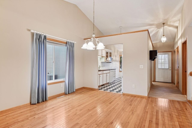 1040 Primrose Ln, Waconia, MN 55387 - unfurnished dining area with light wood-style flooring, a chandelier, and vaulted ceiling