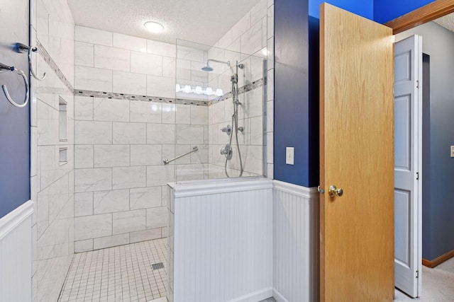 1040 Primrose Ln, Waconia, MN 55387 - full bathroom featuring wainscoting, walk in shower, a textured ceiling, and a decorative wall