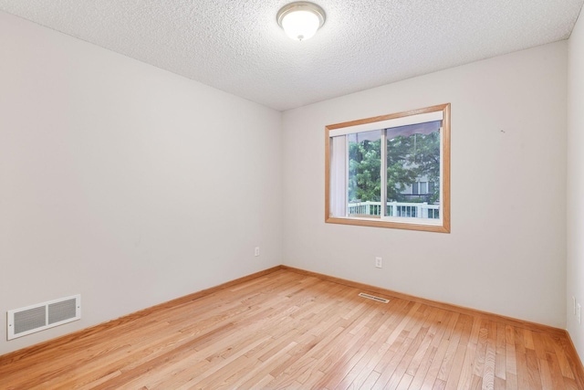 1040 Primrose Ln, Waconia, MN 55387 - spare room featuring wood-type flooring and a textured ceiling