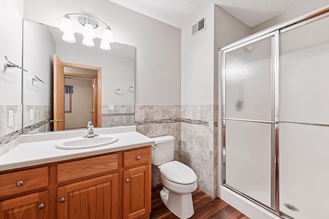 1040 Primrose Ln, Waconia, MN 55387 - full bathroom with tile walls, a stall shower, vanity, wood finished floors, and wainscoting