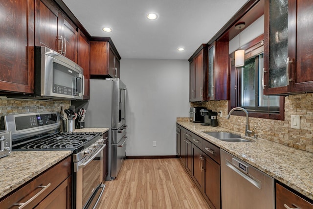 12940 8th Ave N, Zimmerman, MN 55398 - kitchen featuring appliances with stainless steel finishes, recessed lighting, light wood-type flooring, light stone counters, and tasteful backsplash