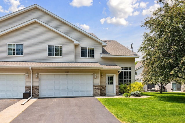 5425 Fawn Ct SE, Prior Lake, MN 55372 - view of front of home with a front lawn, brick siding, asphalt driveway, a garage, and roof with shingles