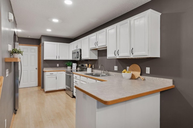 5425 Fawn Ct SE, Prior Lake, MN 55372 - kitchen with appliances with stainless steel finishes, a peninsula, light wood-style flooring, light countertops, and white cabinets