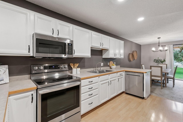 5425 Fawn Ct SE, Prior Lake, MN 55372 - kitchen with appliances with stainless steel finishes, light countertops, a textured ceiling, white cabinetry, and a chandelier