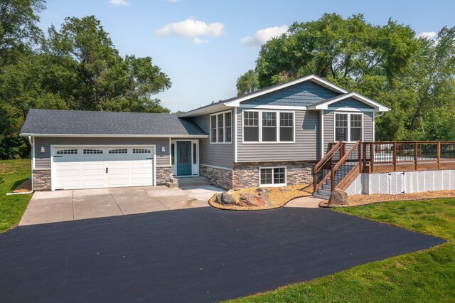 13912 80th St NE, Otsego, MN 55330 - view of front of house featuring driveway, stone siding, an attached garage, stairway, and a deck