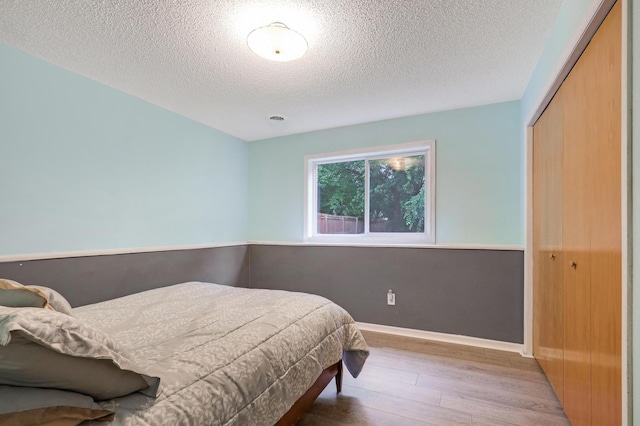 1310 Widgeon Way, Buffalo, MN 55313 - bedroom featuring wood finished floors, a textured ceiling, and a closet