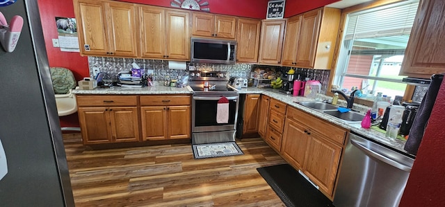 210 E St S, Underwood, MN 56586 - kitchen with stainless steel appliances, a sink, wood finished floors, backsplash, and light countertops