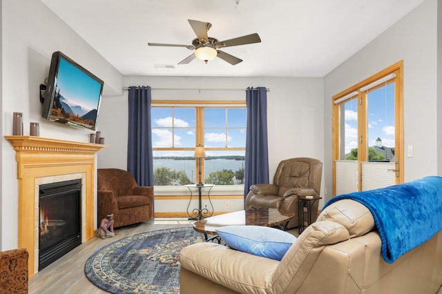 4100 Spring St Unit 310, Spring Park, MN 55384 - living area with wood finished floors, a glass covered fireplace, healthy amount of natural light, and ceiling fan